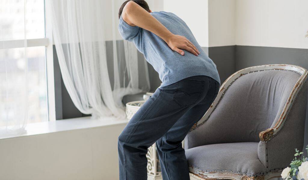 Patient experiencing sciatica symptoms in lower back and leg