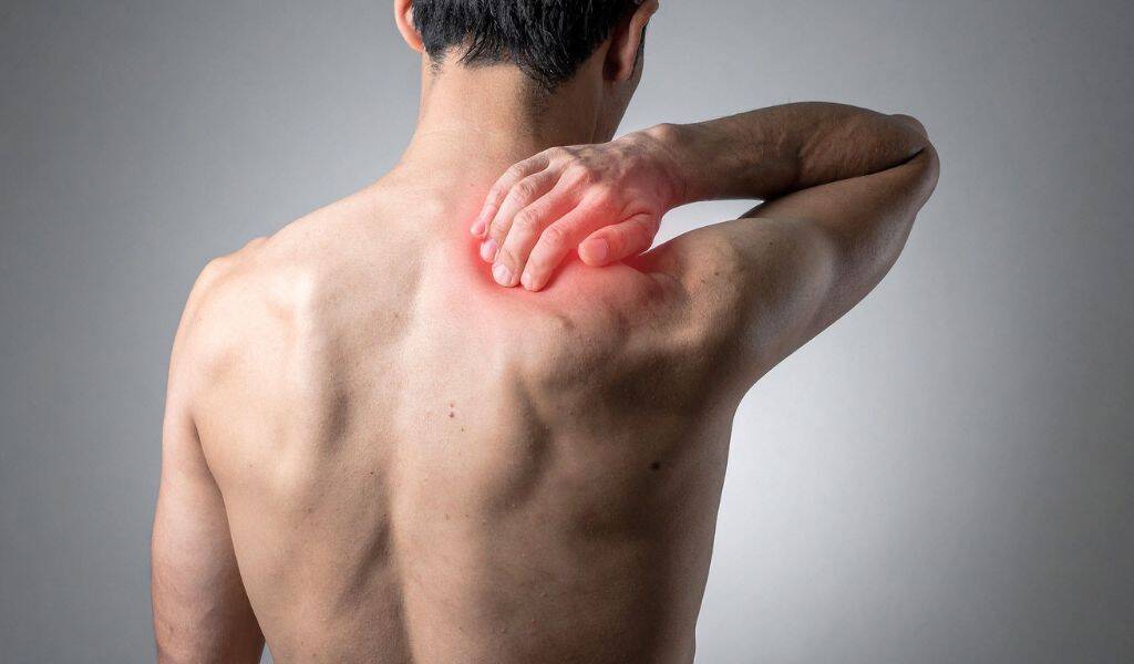 Patient holding shoulder in pain from a rotator cuff injury, treated at District Wellness, Arlington, VA